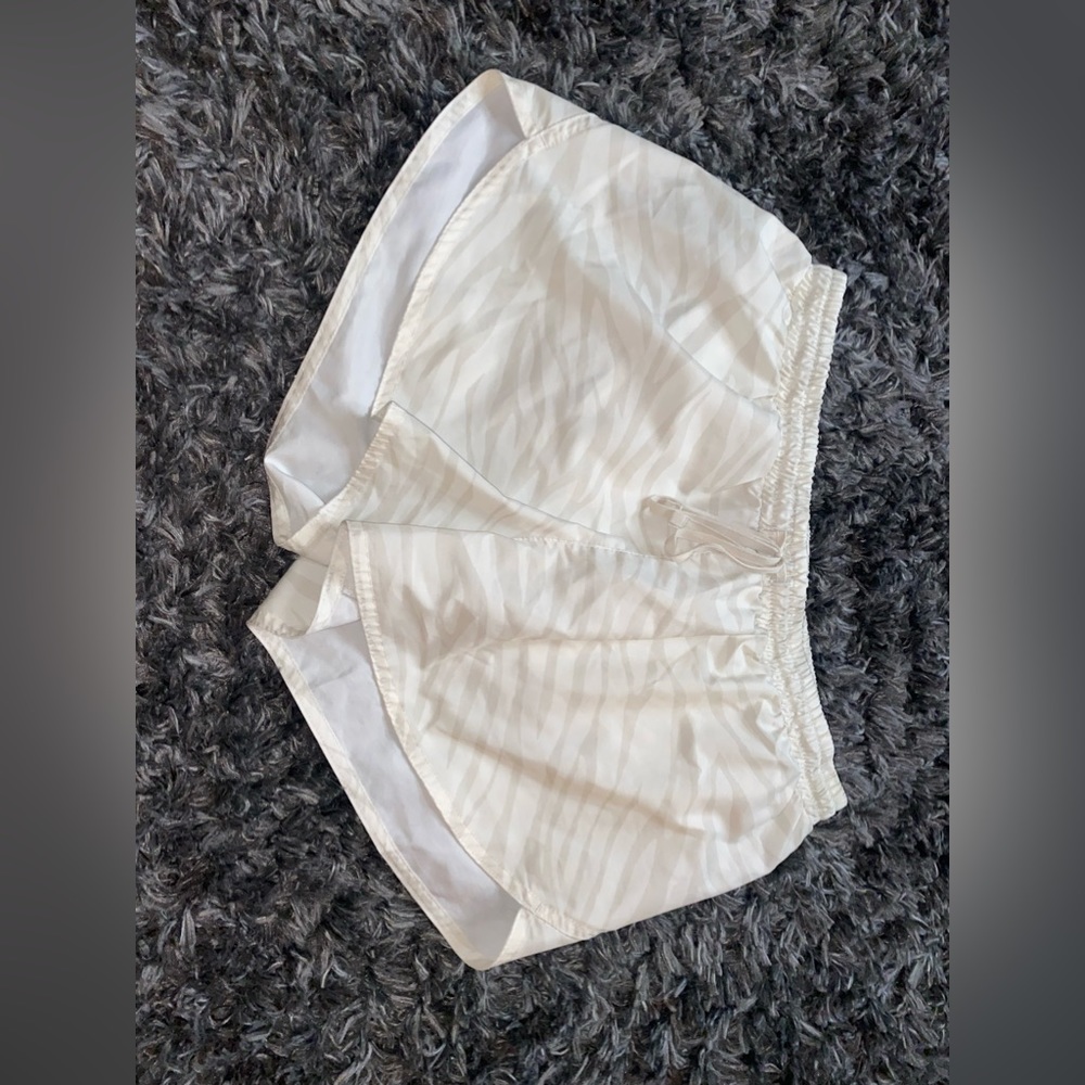 Cream colored workout shorts with darker tan colors through them. Size medium